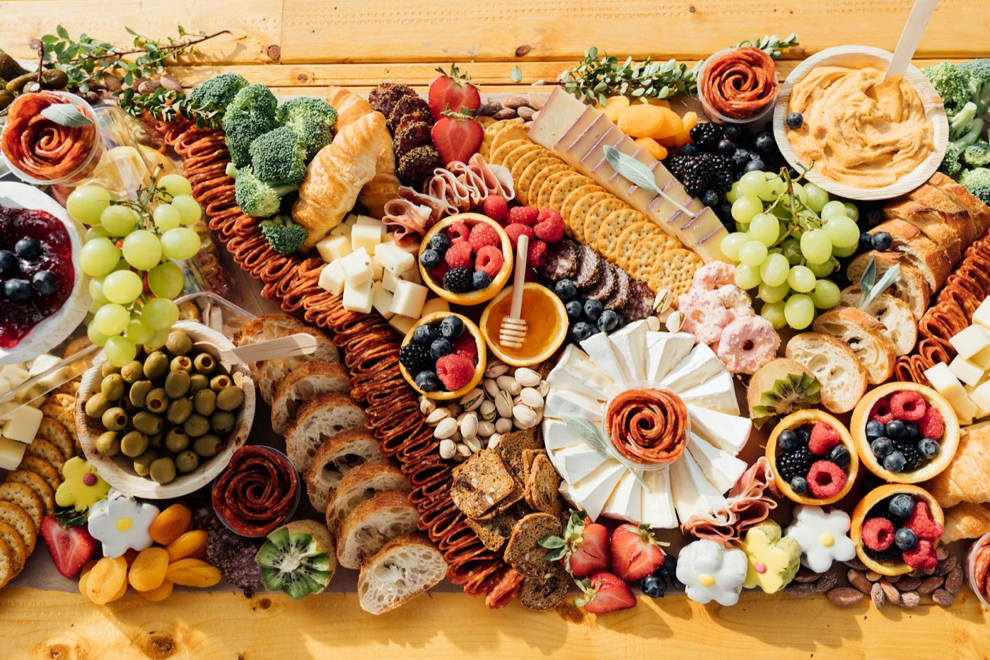 Top-down charcuterie and cheese board with bread and condiments